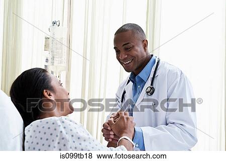 Doctor holding hands with patient View Large Photo Image Stock Photo - Doctor holding hands with patient. Fotosearch