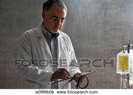 Stock Image - Doctor writing at medical chart. Fotosearch
