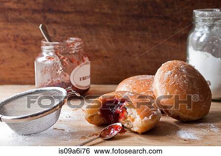 Stock Photograph - Doughnuts, jam and sugar on table. Fotosearch