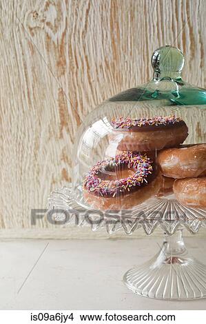 Picture - Doughnuts under glass jar. Fotosearch