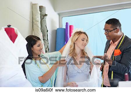 Dressmakers working with bride View Large Photo Image Stock Image - Dressmakers working with bride. Fotosearch