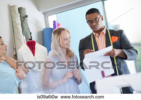 Dressmakers working with bride View Large Photo Image Stock Photo - Dressmakers working with bride. Fotosearch