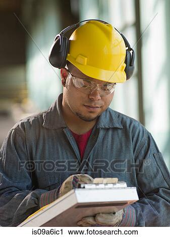 Stock Image - Engineer making notes on site. Fotosearch