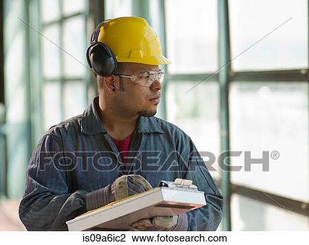 Stock Image - Engineer making notes on site. Fotosearch