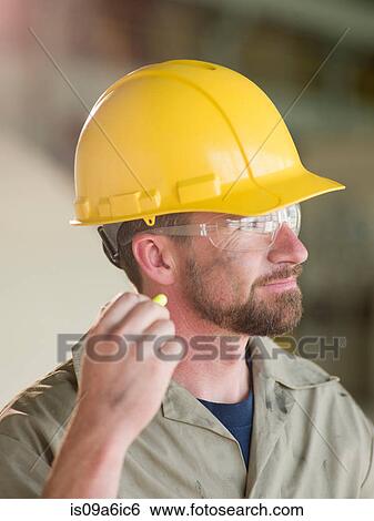 Engineer wearing earplugs on site View Large Photo Image Stock Photograph - Engineer wearing earplugs on site. Fotosearch