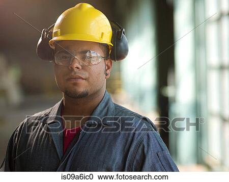 Stock Image - Engineer wearing hard hat on site. Fotosearch
