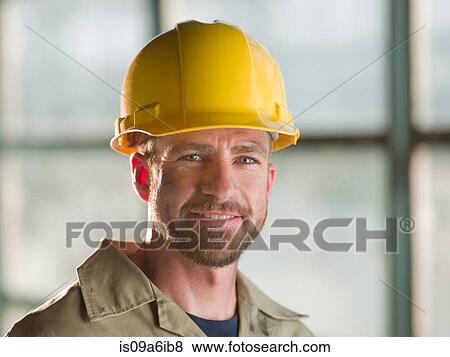 Stock Photo - Engineer wearing hard hat on site. Fotosearch