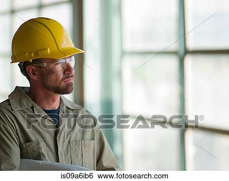 Engineer wearing hard hat on site View Large Photo Image Stock Photograph - Engineer wearing hard hat on site. Fotosearch