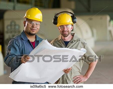 Stock Photography - Engineers reading blueprints on site. Fotosearch