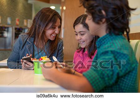 Stock Photograph - Family having frozen yogurt in store. Fotosearch