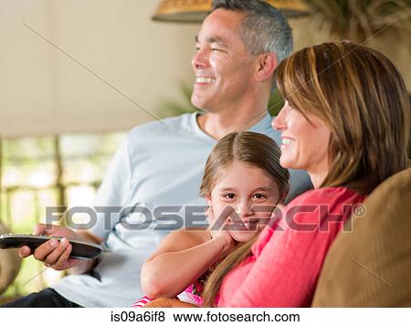 Stock Photo - Family relaxing together on sofa. Fotosearch