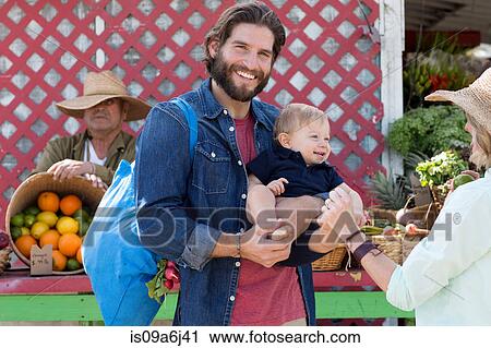 Stock Image - Family shopping at farmer's market. Fotosearch