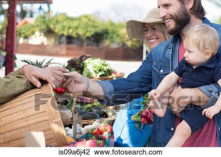 Stock Image - Family shopping at farmer's market. Fotosearch