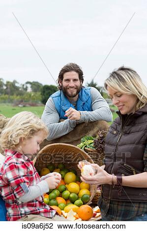 Stock Image - Family shopping at farmer's market. Fotosearch