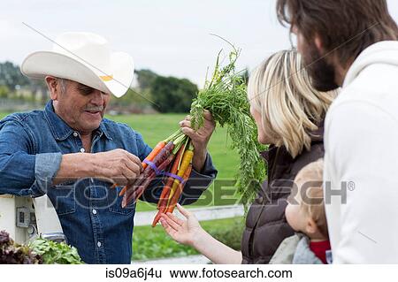 Stock Photograph - Family shopping at farmer's market. Fotosearch