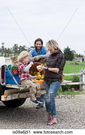 Stock Image - Family with produce in truck bed. Fotosearch