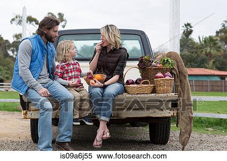 Stock Photography - Family with produce in truck bed. Fotosearch