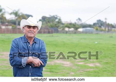 Farmer smiling in grassy field View Large Photo Image Stock Image - Farmer smiling in grassy field. Fotosearch
