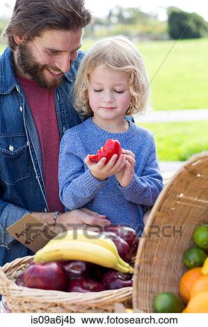 Stock Image - Father and son at farmer's market. Fotosearch
