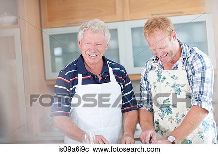 Stock Image - Father and son cooking in kitchen. Fotosearch