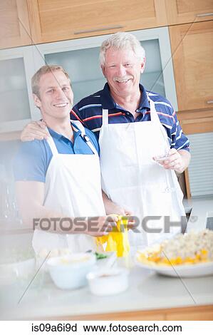 Stock Image - Father and son cooking in kitchen. Fotosearch