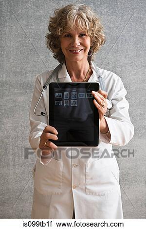 Stock Image - Female doctor showing digital tablet screen. Fotosearch