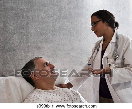 Stock Photograph - Female doctor talking to male patient. Fotosearch