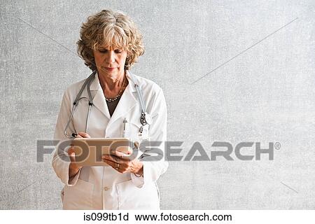 Stock Image - Female doctor using at digital tablet. Fotosearch