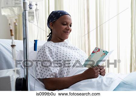 Stock Photograph - Female hospital patient reading get well card. Fotosearch