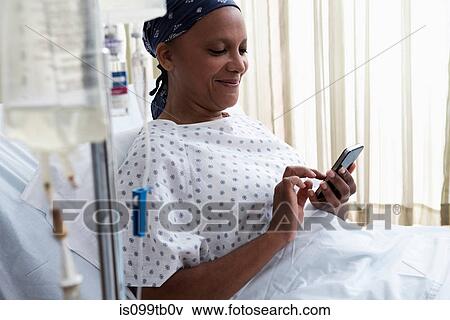 Stock Photo - Female hospital patient using cellphone. Fotosearch