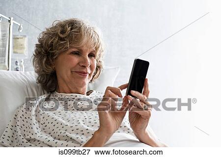 Stock Photo - Female hospital patient using cellphone. Fotosearch