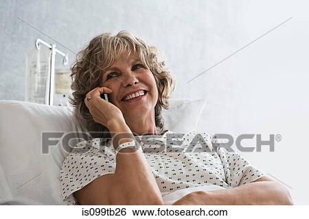 Stock Photograph - Female hospital patient using cellphone. Fotosearch