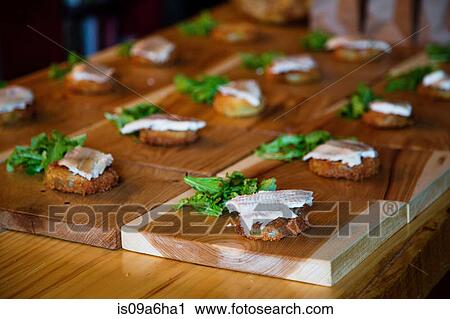 Stock Image - Fish patties with lettuce on boards. Fotosearch