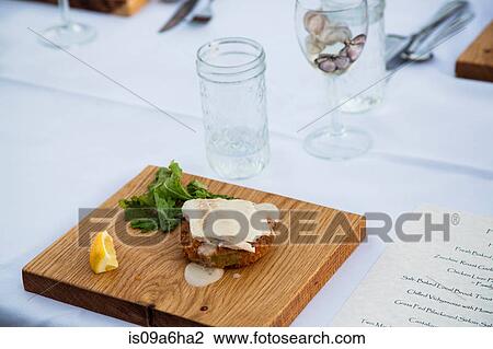 Stock Image - Fish patty with lettuce on board. Fotosearch