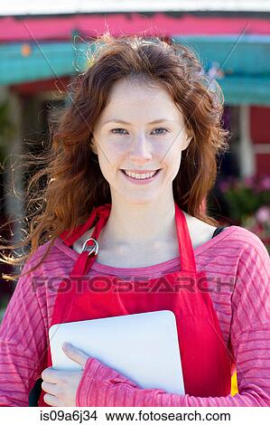 Picture - Florist holding notebook in shop. Fotosearch