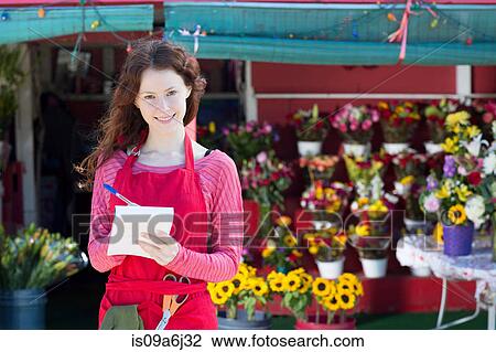 Florist making notes in shop View Large Photo Image Stock Image - Florist making notes in shop. Fotosearch
