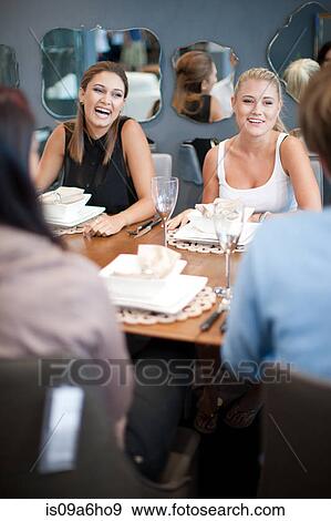 Stock Photo - Friends talking at dinner table. Fotosearch