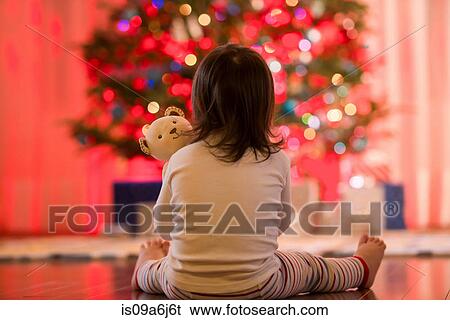 Stock Photograph - Girl admiring Christmas tree. Fotosearch
