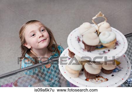 Girl admiring cupcakes in bakery View Large Photo Image Stock Photograph - Girl admiring cupcakes in bakery. Fotosearch