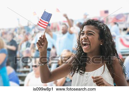 Stock Image - Girl cheering and waving american flag. Fotosearch