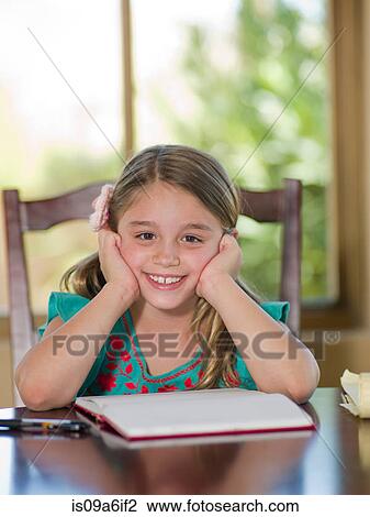 Girl doing homework at table View Large Photo Image Stock Image - Girl doing homework at table. Fotosearch