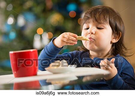 Girl eating Christmas cookies View Large Photo Image Stock Image - Girl eating Christmas cookies. Fotosearch