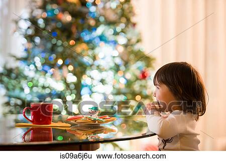 Girl eating Christmas cookies View Large Photo Image Stock Photograph - Girl eating Christmas cookies. Fotosearch