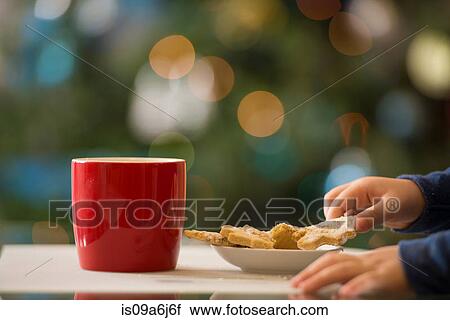 Stock Image - Girl having Christmas cookies. Fotosearch