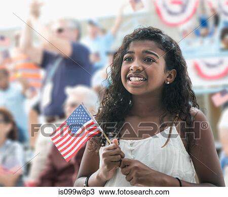 Stock Image - Girl holding american flag, looking anxious. Fotosearch