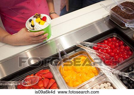 Girl putting toppings on frozen yogurt View Large Photo Image Stock Image - Girl putting toppings on frozen yogurt. Fotosearch