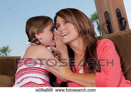 Stock Photo - Girl whispering in mother's ear. Fotosearch