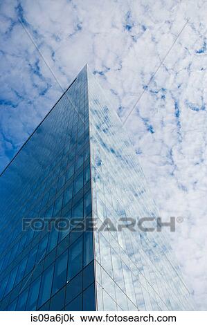 Stock Image - Glass skyscraper and cloudy sky. Fotosearch