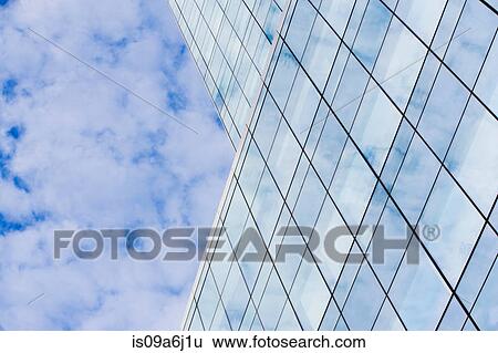 Stock Photograph - Glass skyscraper and cloudy sky. Fotosearch
