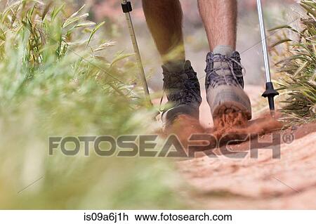 Stock Image - Hiker walking on dirt path. Fotosearch